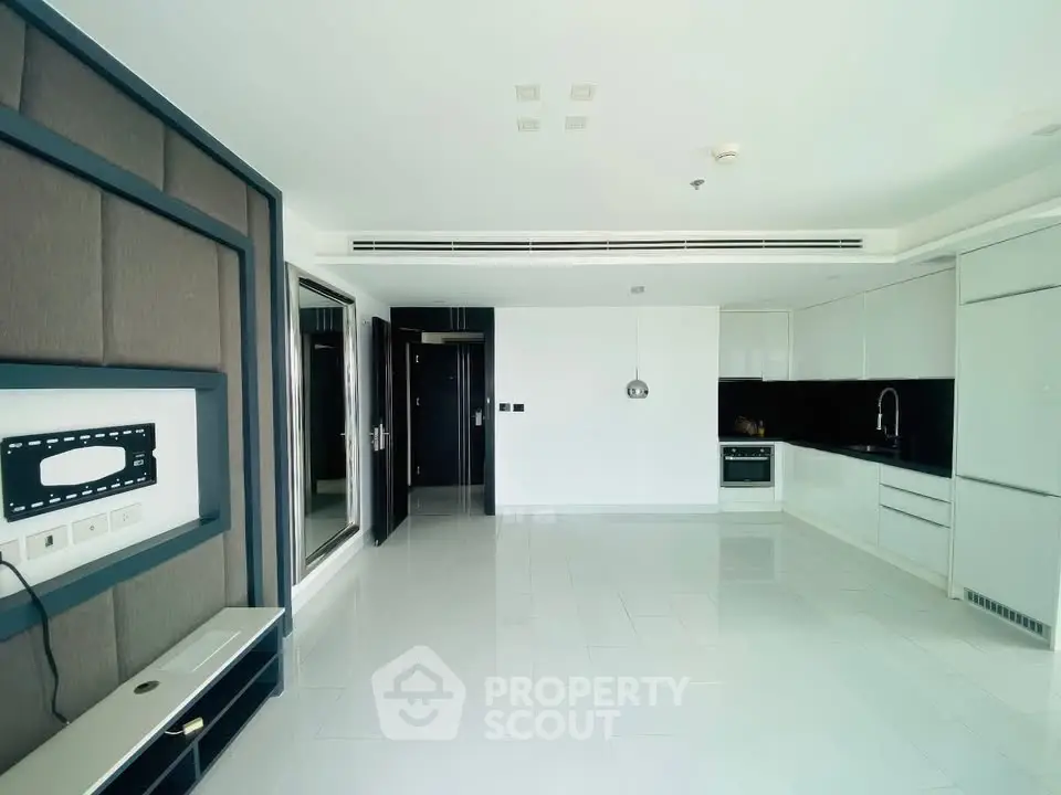 Spacious modern living room with sleek kitchen and built-in entertainment unit