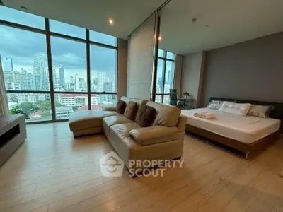 Luxurious open-plan living room with stunning city view and modern furnishings.