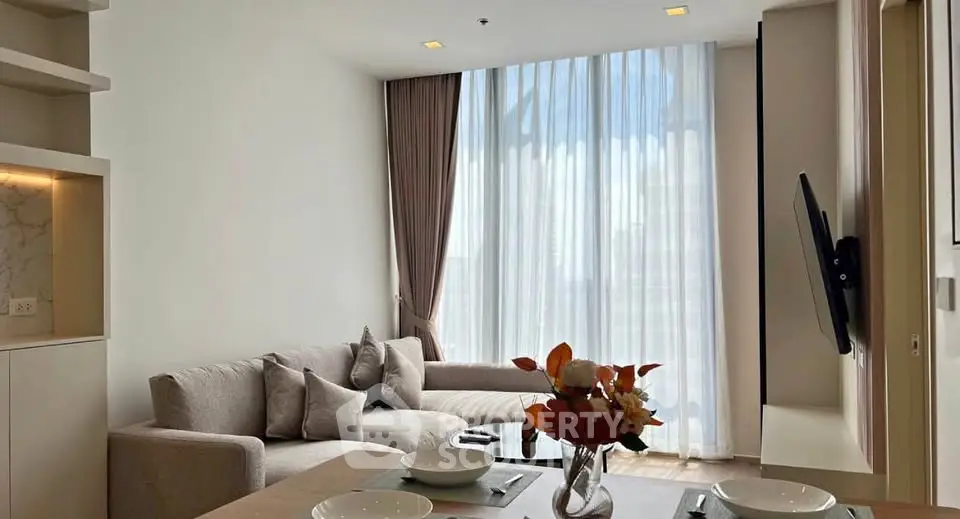 Modern living room with elegant decor and large window offering natural light