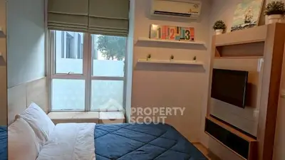 Cozy bedroom with modern decor and large window for natural light.