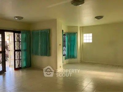 Spacious living room with natural light and tiled flooring, ideal for modern living.