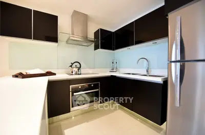 Modern kitchen with sleek black cabinets and stainless steel appliances