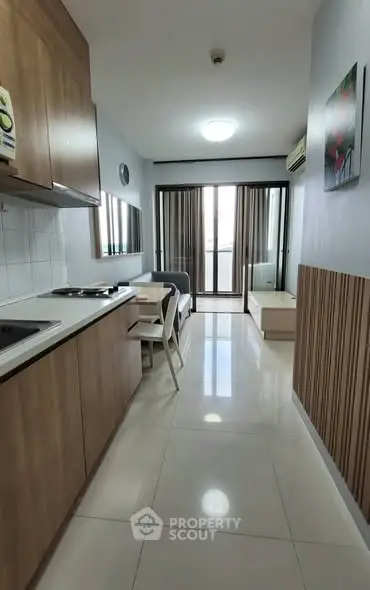 Modern compact kitchen with open layout and sleek design in a cozy apartment.