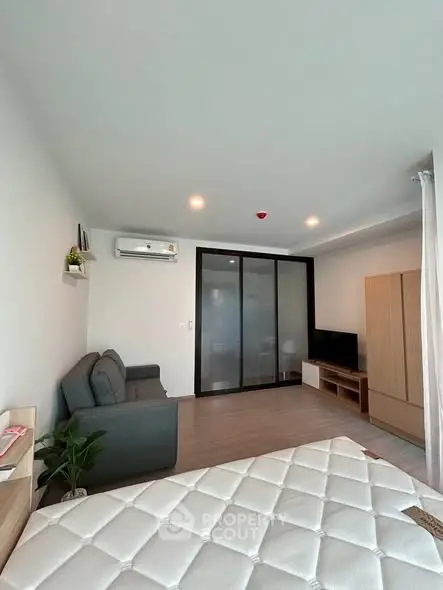 Modern studio apartment with sleek design and cozy furnishings, featuring a comfortable sofa and stylish decor.