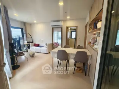 Spacious modern living room with dining area and large windows offering natural light.