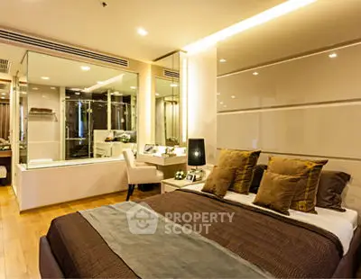 Luxurious bedroom with modern decor and glass-enclosed bathroom, perfect for a stylish urban lifestyle.