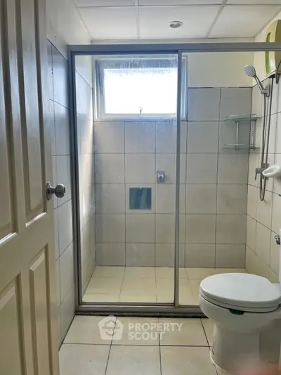 Modern bathroom with glass shower and tiled walls, perfect for a sleek home design.