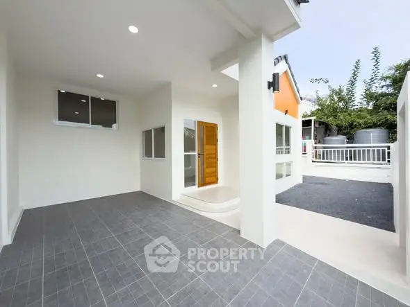 Modern home exterior with spacious tiled patio and sleek design