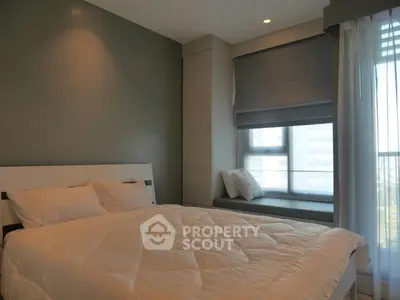 Modern bedroom with cozy bed and large window seat in stylish apartment.