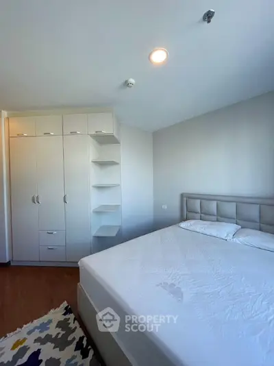 Spacious bedroom with modern wardrobe and large bed in bright apartment