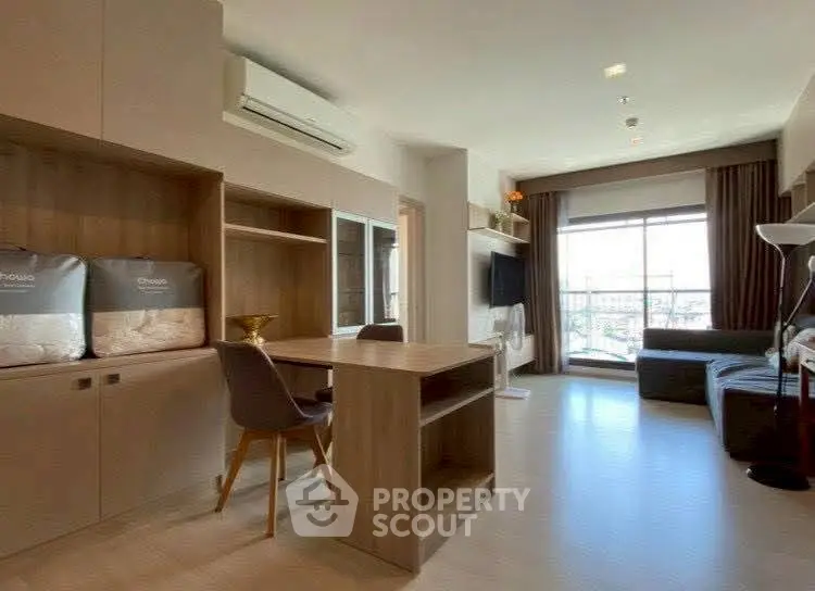 Modern living room with stylish furniture and large window offering city view