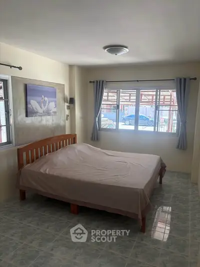Spacious bedroom with large windows and elegant decor, perfect for natural light lovers.