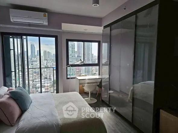 Modern bedroom with city view, large windows, and sleek furniture in urban apartment.