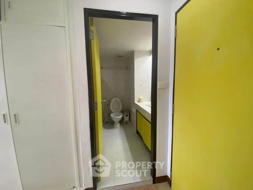 Compact bathroom with yellow accents and modern fixtures