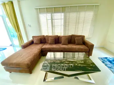 Spacious living room with stylish brown sectional sofa and modern glass coffee table.
