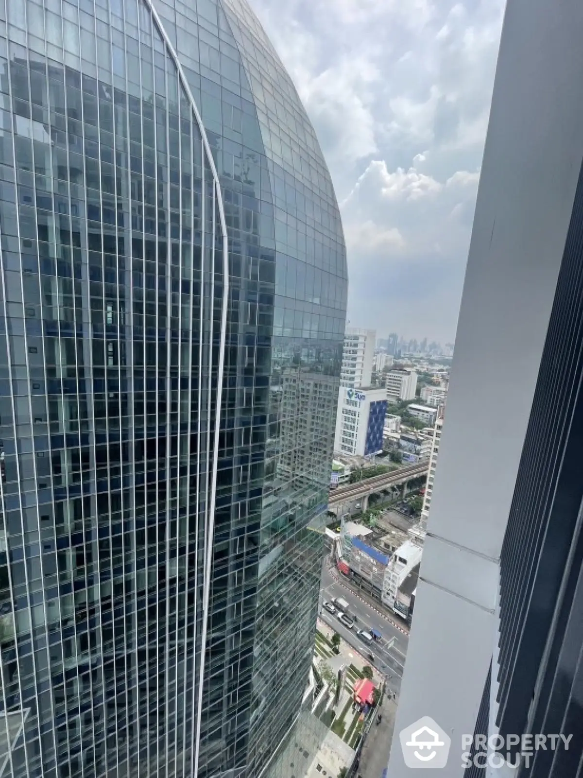 Stunning cityscape view from high-rise building balcony showcasing modern architecture.