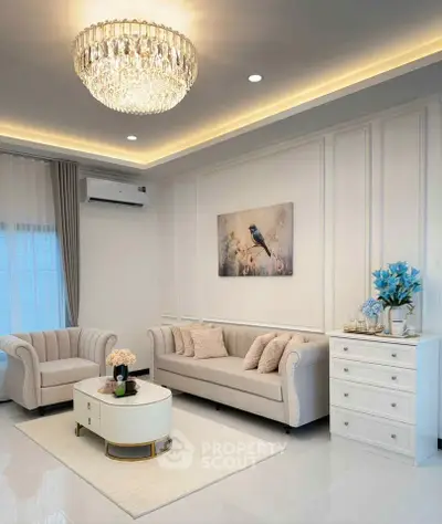 Elegant living room with plush sofas, chandelier, and modern decor