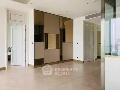 Spacious modern living room with elegant design and large windows offering city views.