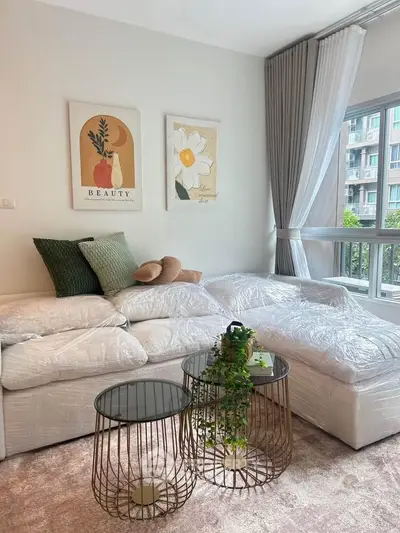 Modern living room with stylish decor and large windows offering natural light.