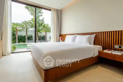 Luxurious bedroom with garden view, featuring elegant wooden accents and large windows for natural light.