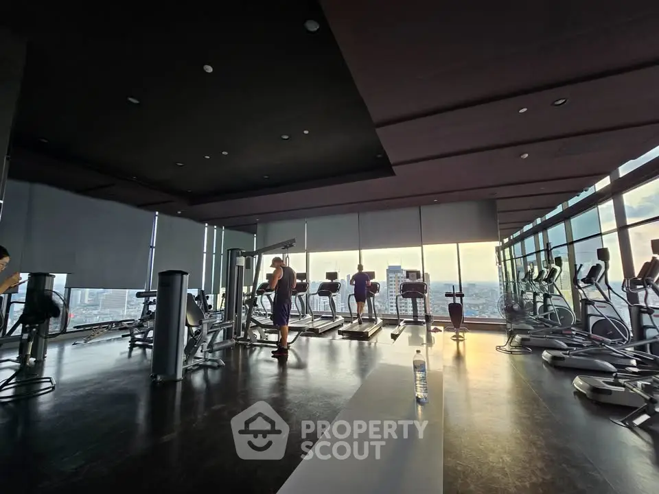 Modern high-rise gym with panoramic city views and state-of-the-art equipment.