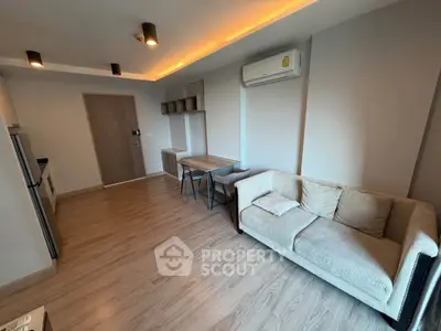 Modern living room with cozy sofa and dining area, featuring sleek wooden flooring and ambient lighting.