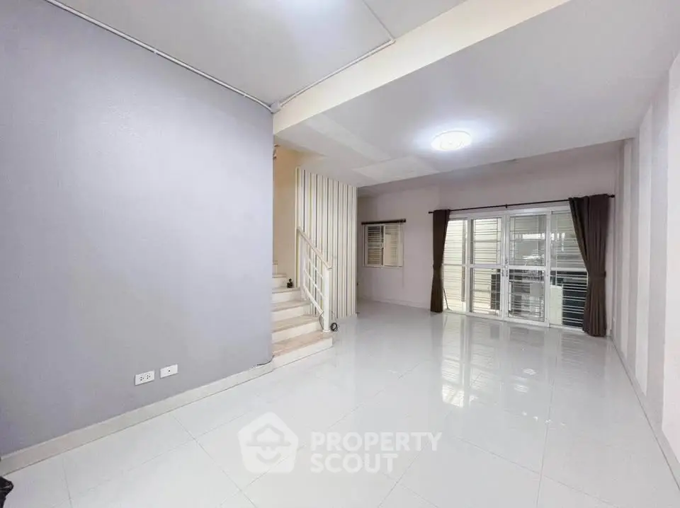Spacious modern living room with staircase and large windows