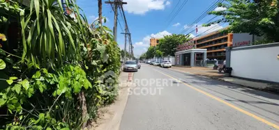 Street view with lush greenery and modern building, ideal for urban living.