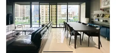 Spacious modern living room with large windows offering stunning city views, sleek furniture, and elegant decor.