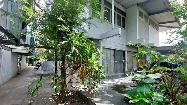 Modern building exterior with lush greenery and spacious driveway