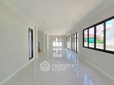 Spacious modern living room with large windows and glossy tile flooring