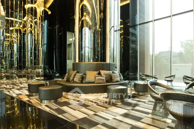Luxurious modern lobby with elegant seating and reflective decor in high-end building.