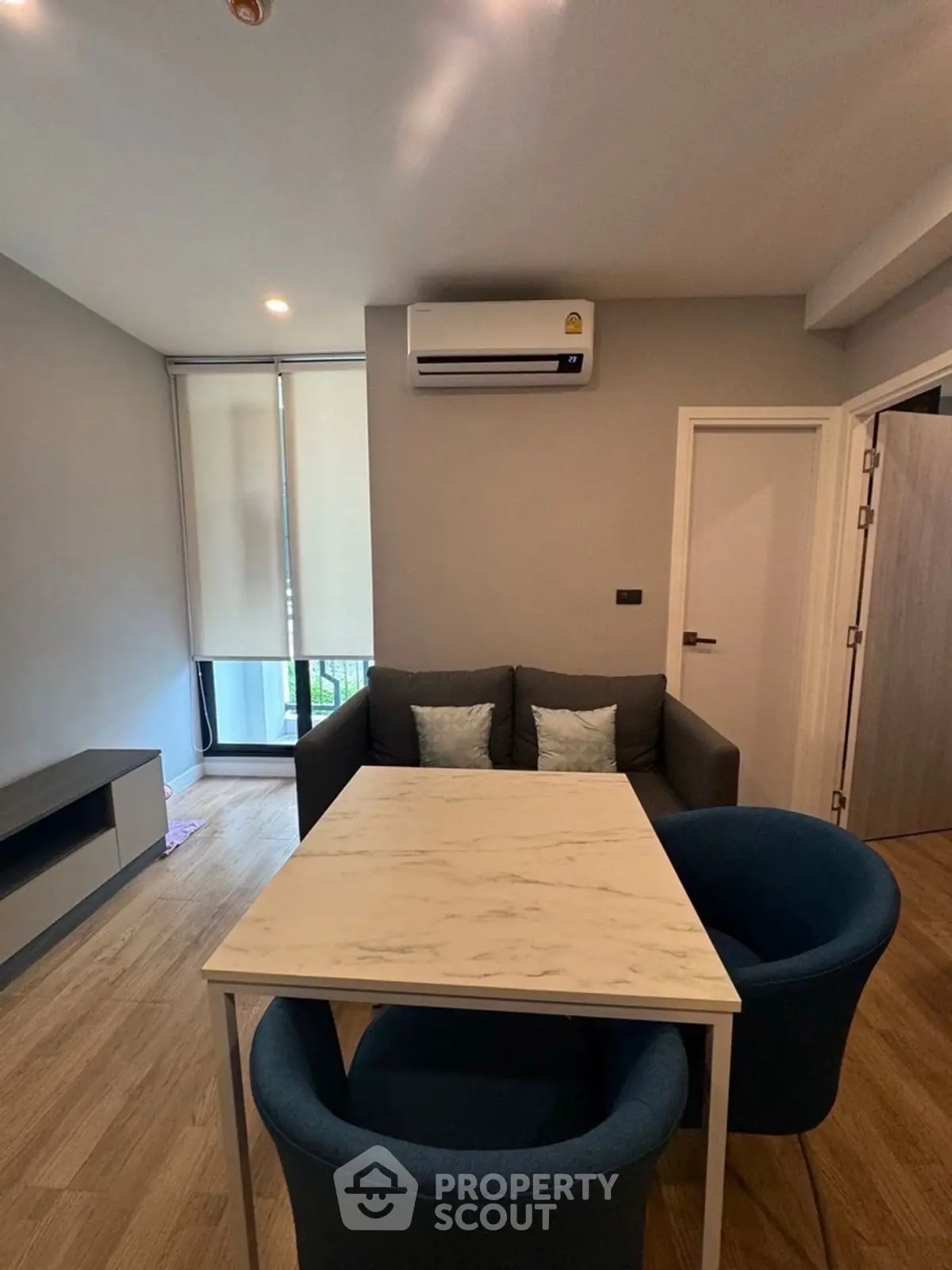Modern living room with cozy seating and air conditioning in a stylish apartment.