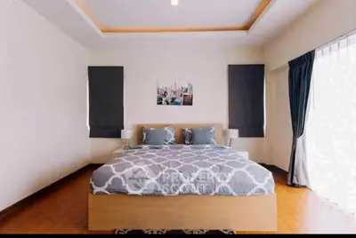 Spacious modern bedroom with stylish decor and large windows for natural light.