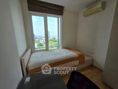 Cozy bedroom with city view, featuring a single bed and air conditioning, perfect for urban living.