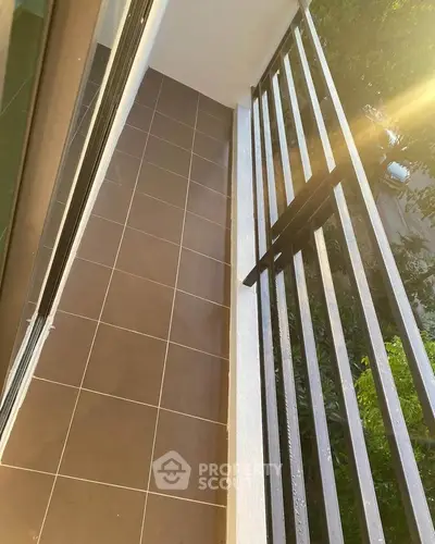 Charming narrow balcony with modern railing and tiled flooring, perfect for urban living.