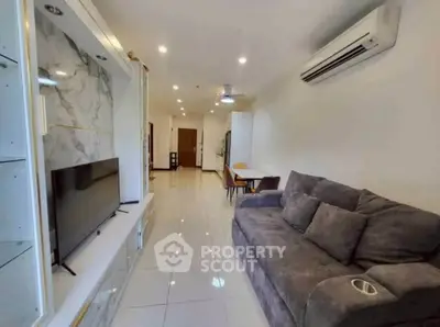 Modern living room with sleek design, featuring a plush sofa, wall-mounted TV, and elegant marble accents.