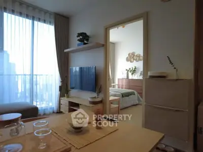 Modern apartment interior with open living room and bedroom view, featuring stylish decor and natural light.