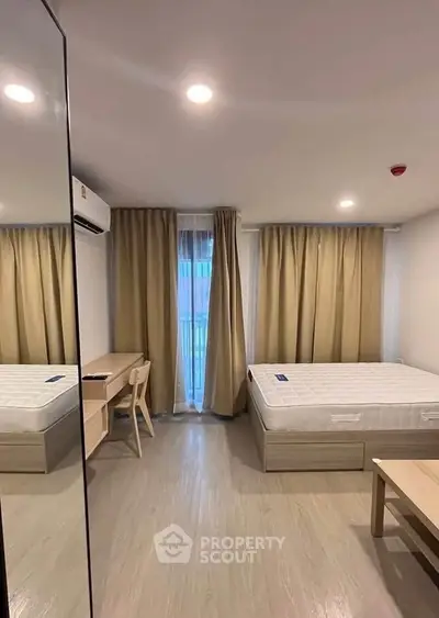 Modern bedroom with minimalist design, featuring a comfortable bed, desk, and large window with curtains.