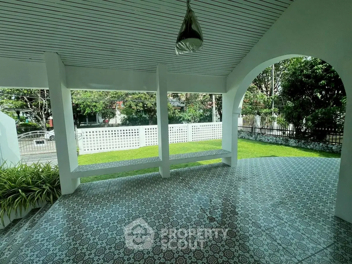 Charming covered patio with decorative tiles and lush garden view