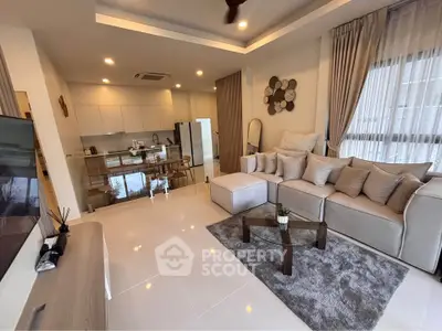 Modern living room with open kitchen, stylish decor, and natural light
