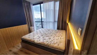 Modern bedroom with city view, featuring a cozy bed and ambient lighting.