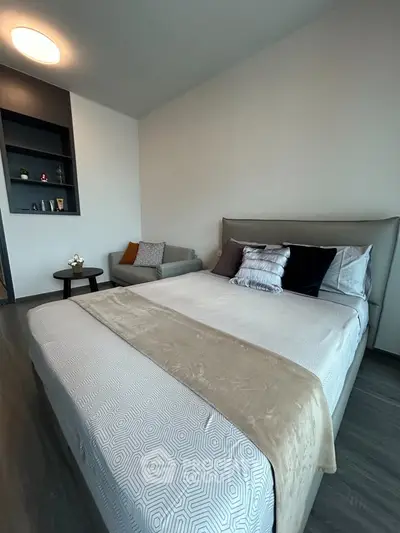 Modern bedroom with stylish decor and cozy seating area, perfect for relaxation.