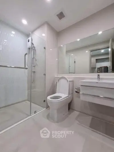 Modern bathroom with glass shower and sleek fixtures in a contemporary apartment.