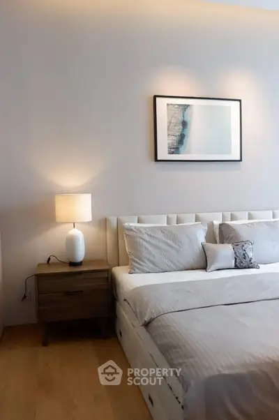 Elegant bedroom with modern decor and cozy ambiance, featuring a stylish bed and bedside lamp.