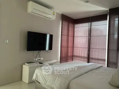 Modern bedroom with air conditioning and wall-mounted TV, featuring sleek design and natural light.