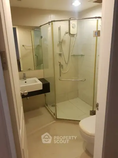 Modern bathroom with glass shower enclosure and sleek fixtures