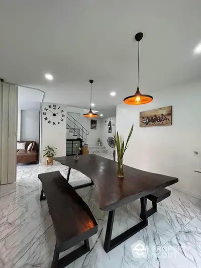 Modern dining area with unique wooden table and stylish lighting