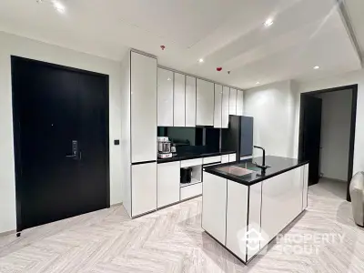 Sleek modern kitchen with high-gloss cabinetry and central island in a luxurious apartment with sophisticated marble flooring.