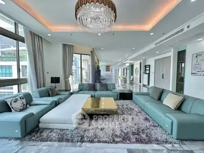 Luxurious modern living room with elegant chandelier and spacious seating area.